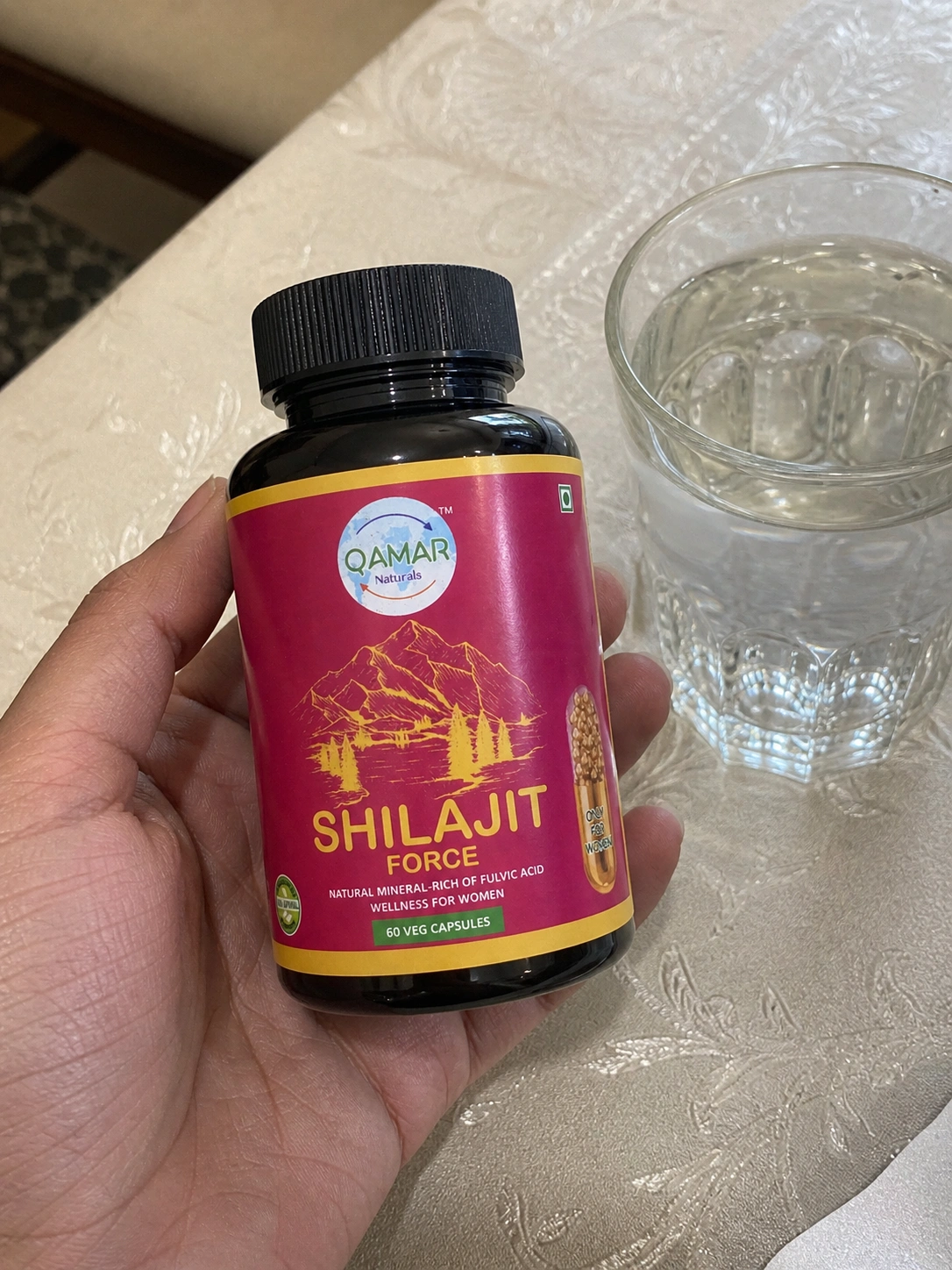 Woman holding Qamar Naturals Shilajit Force bottle